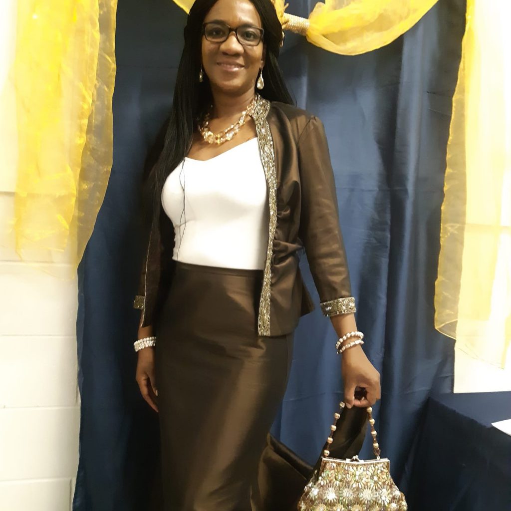 A person stands and smiles at the camera.