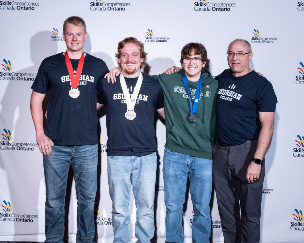From left: Georgian’s medalists from the Outdoor Powered Equipment category, Logan Wilkey, Parker Jansen and Jacob Hill with Bob Dundas, Marine Engine Mechanic Professor.