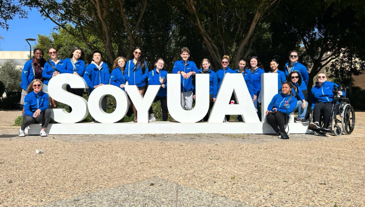 Group of students in front of a sign at Universidad de Almeria.
