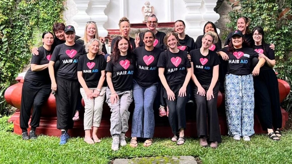 A group of students from Georgian's Hairstyling diploma program wearing black Hair Aid t-shirts with a heart on them visited Guatemala in 2024 to teach locals how to cut hair and start their own micro-businesses. 