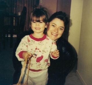 An adult and a child pose for a photo together.
