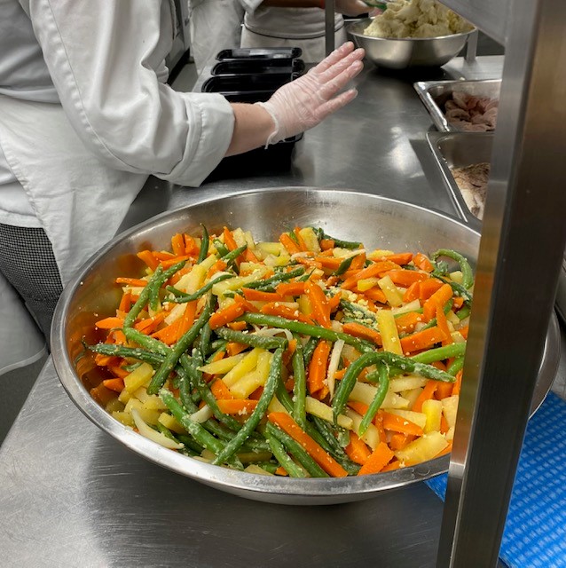 A big metal bowl of mixed vegetables