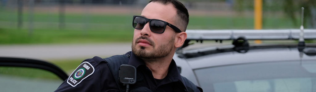 Evan Gorman, Georgian alumnae stands beside a police cruiser.