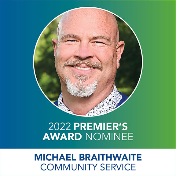 Head shot of a smiling man (Michael Braithwaite) in a circle with the text 2022 Premier's Award Nominee