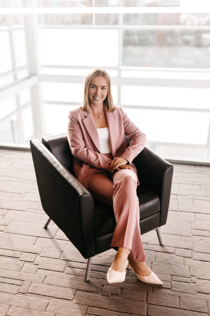 Woman in pink suit sitting on chair