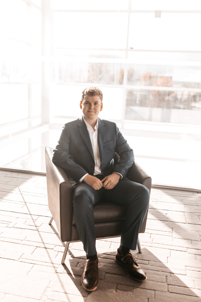 Man in blue suit sitting on chair