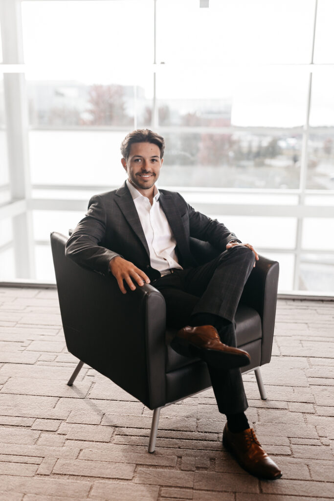 Man in grey suit sitting in chair