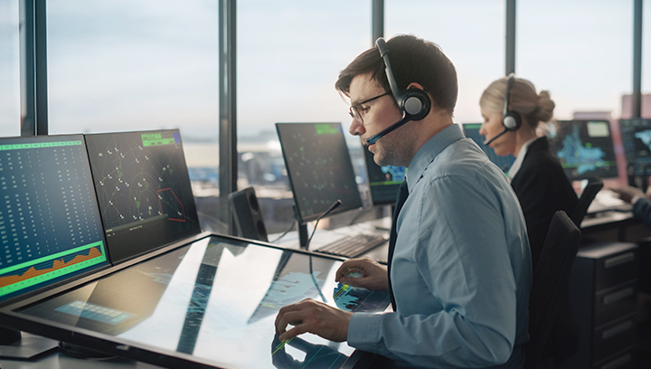 Aviation industry professional sitting in front of flight simulator equipment workstation