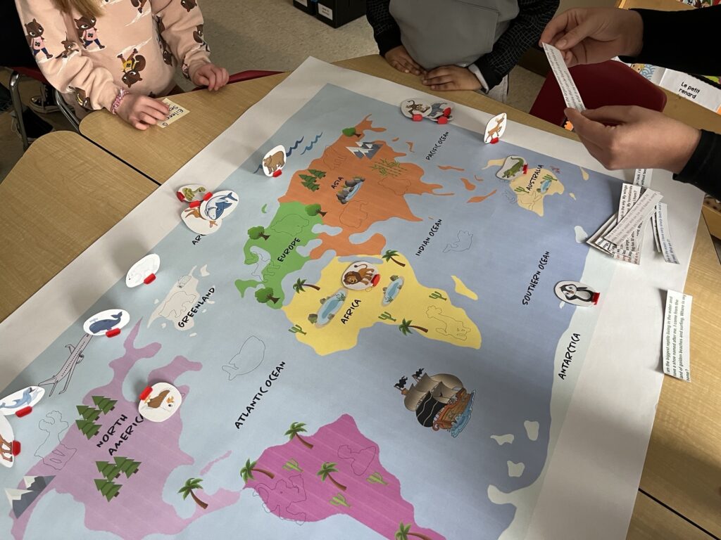 A colourful drawn map of the world with stickers of different animals on it.