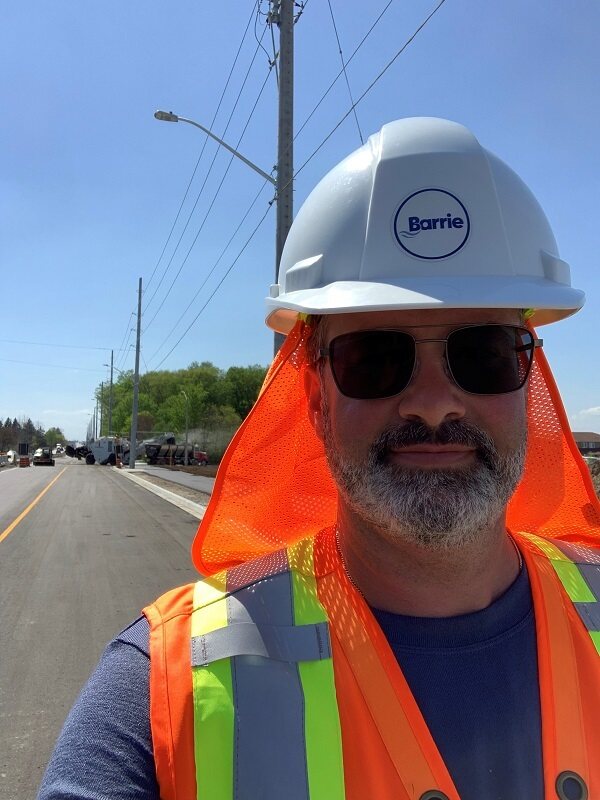Dave outside on street wearing City of Barrie construction hat and safety vest