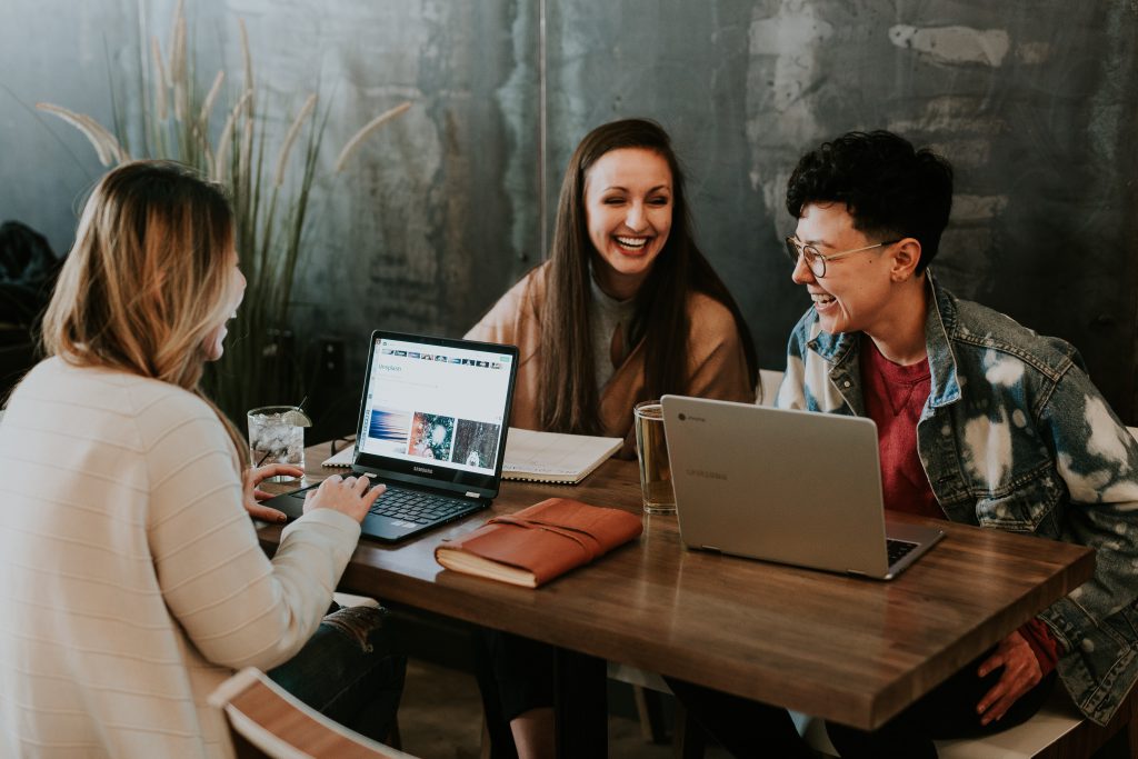 students sitting at a table with laptops
