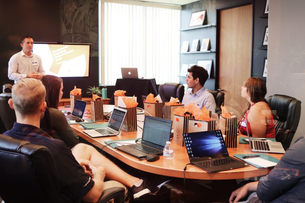 A bunch of people sitting in a boardroom learning from an instructor