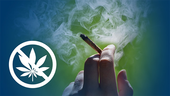 A hand holding a lit joint containing marijuana between the index finger and middle finger, surrounded by smoke, with an icon overlay indicating no cannabis allowed