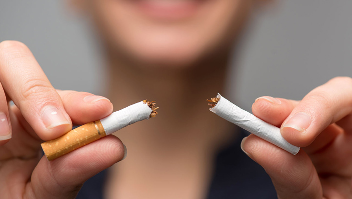 female hands holding a cigarette butt that has been broken in half
