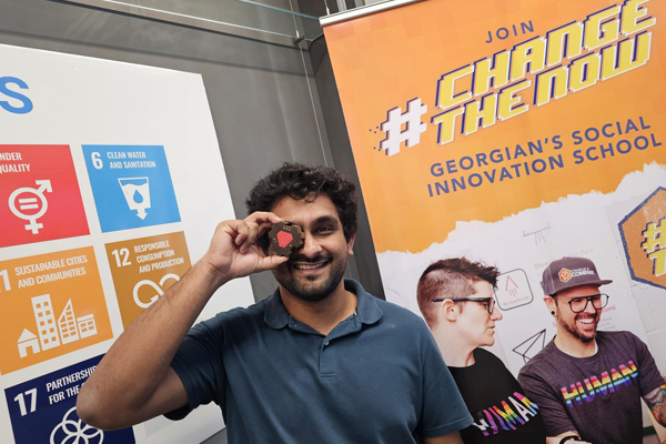 Georgian student in front of ChangeTheNow banner