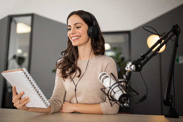 A female faculty recording a podcast while reading