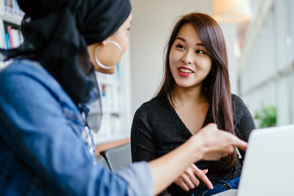 Image of a student and faculty discussing near laptop