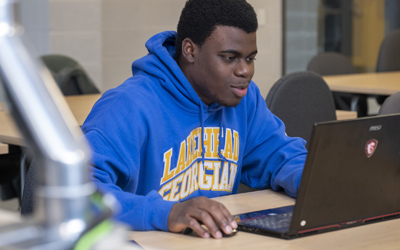 Image of a male student working on laptop