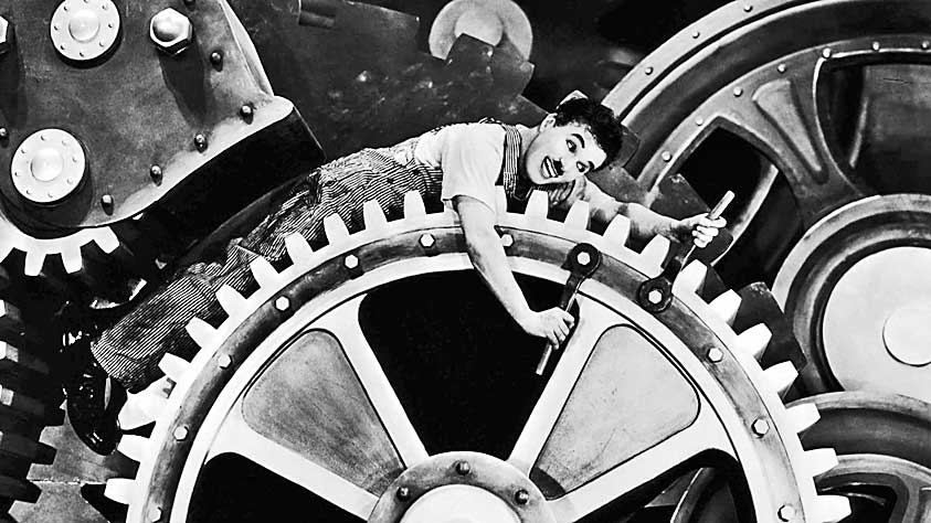 A picture of Charlie Chaplin inside a gear mechanism.