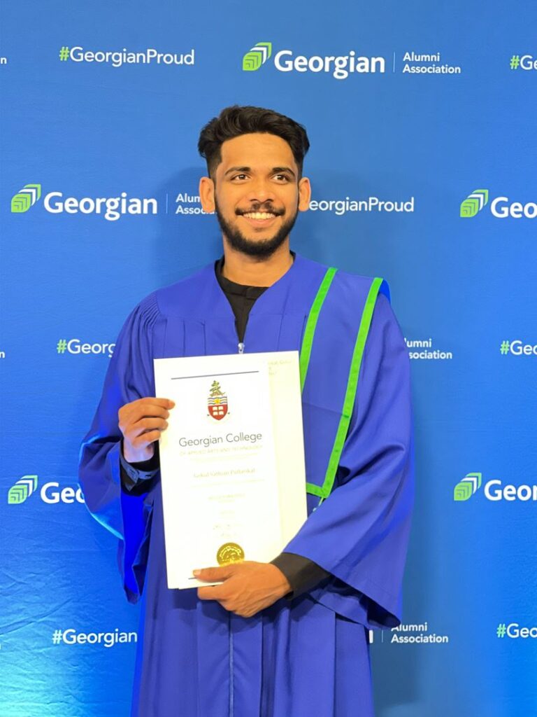 A person wearing a blue convocation gown stands in front of a backdrop reading "Georgian" and holds a diploma.