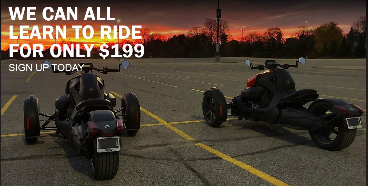 Two Can-Am three-wheeled motorcycles on asphalt with a forest in the background during a sunset