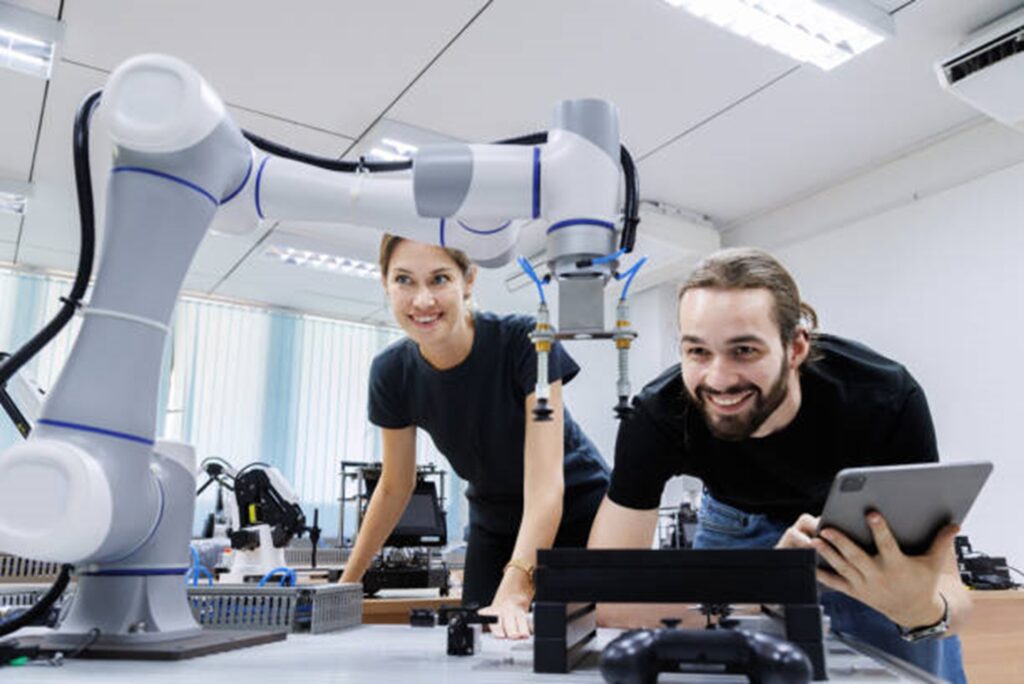 two individuals working with a robot