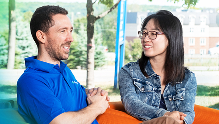 male member of Georgian College's student recruitment team sitting and chatting with a female prospective student