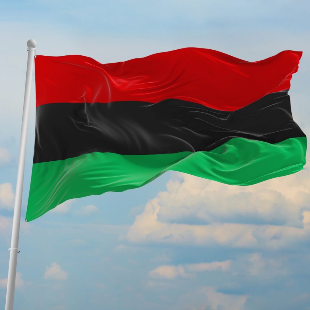 A flag with three horizontal stripes: red on top, black in the middle and green in the bottom.
