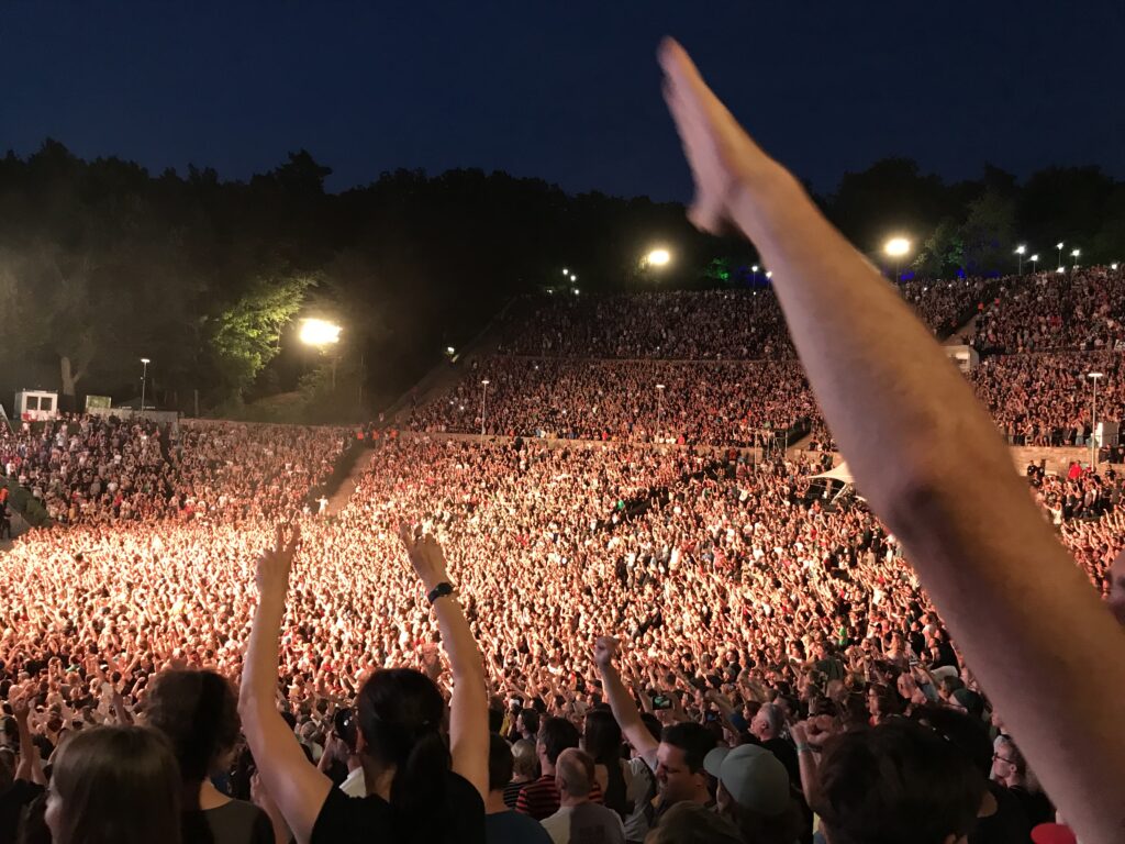 An outdoor stadium filled with people at nighttime. 