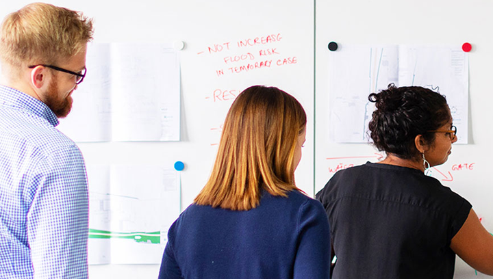 A group of entrepreneurs writing on a white board at the Henry Bernick Entrepreneurship Centre. 
