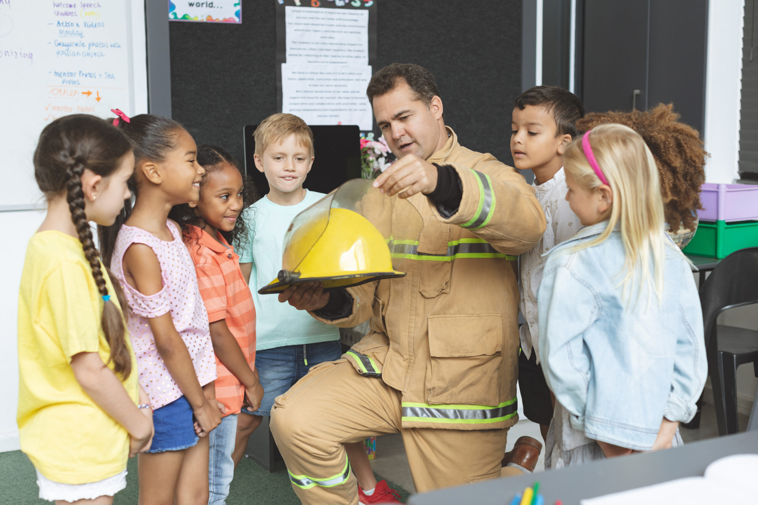 male firefighter educator teaching several children in a classroom
