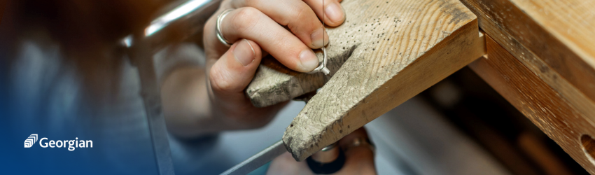 hands working on a silver ring