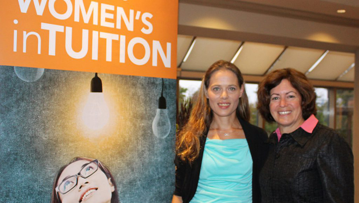 Shivonne OBrien and Giselle Bodkin standing next to a WOMEN's inTUITION poster