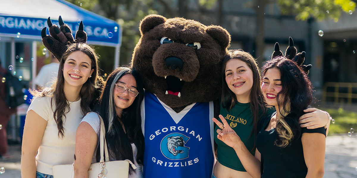 Growler poses with four students outside