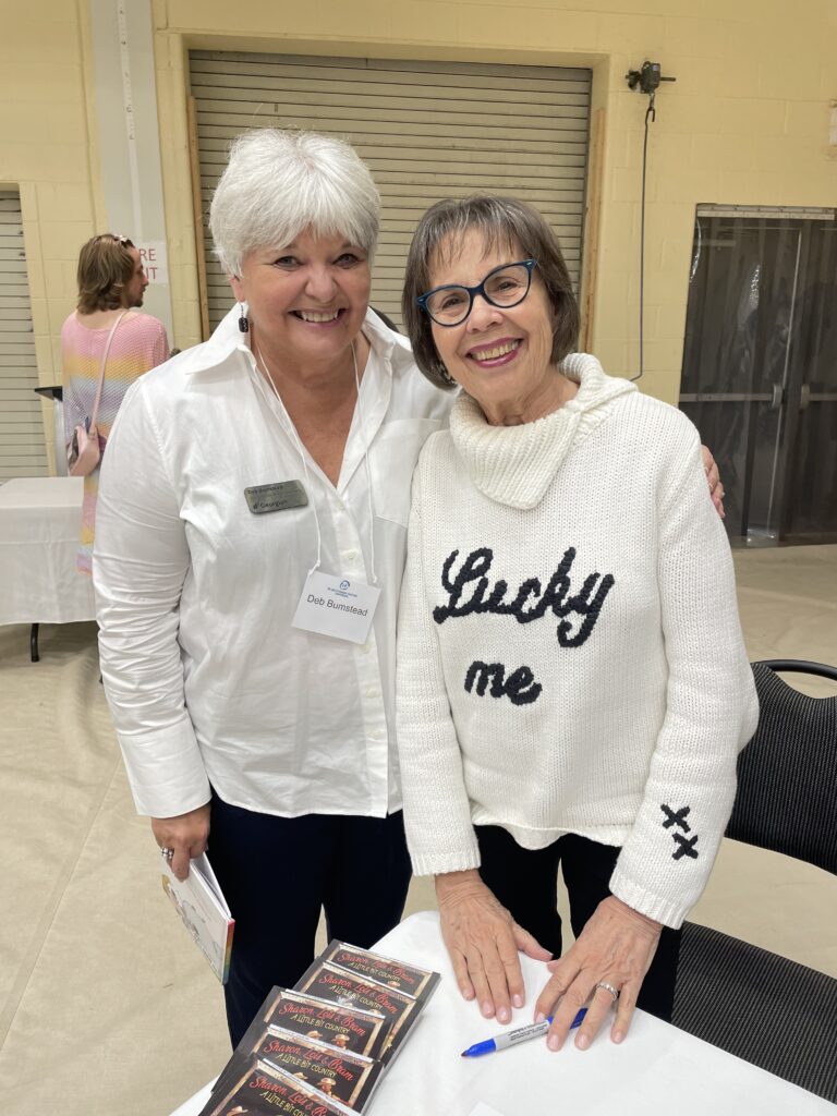 Two people stand together for a photo and smile. 