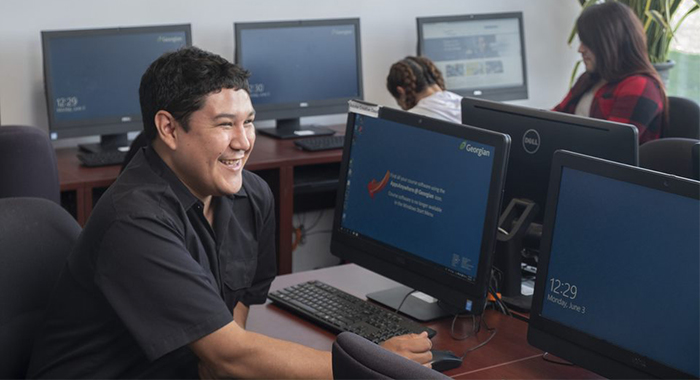 a man of Indigenous ancestry using a computer in the Indigenous Resource Centre at the Georgian College Barrie Campus