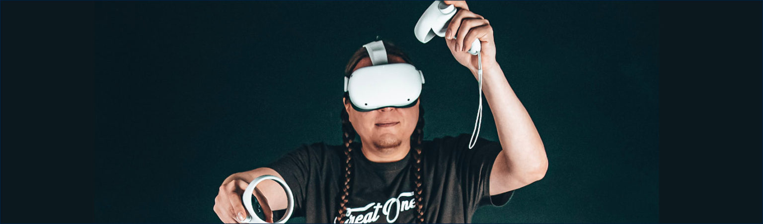 A person wearing a virtual reality head set and holding hand controls