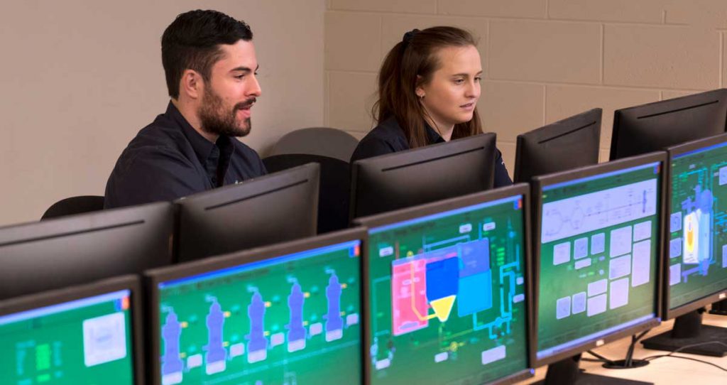 female and male student of Georgian's Marine Engineering Technology program working on emergency duties simulator in a computer lab