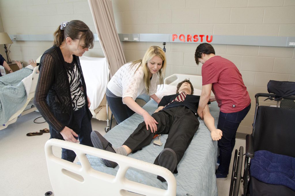 3 students working in the nursing simulation lab