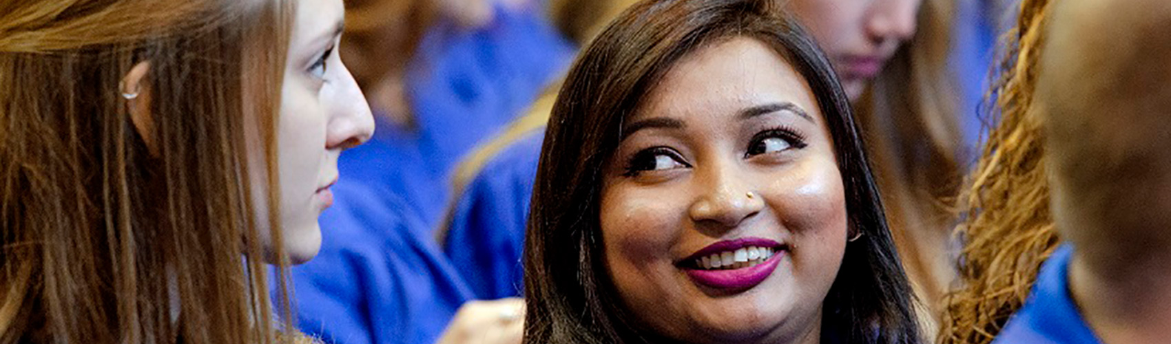 A crowd of Georgian College graduates sitting and wearing blue gowns at a convocation ceremony