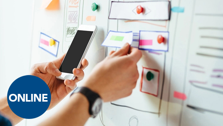 Person's hands holding a cellphone and pinning a sticky note to a whiteboard