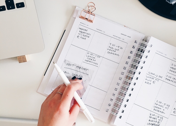 person writing in a daily planner