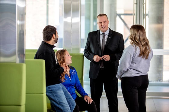 President and CEO Kevin Weaver engaging with students in a hallway