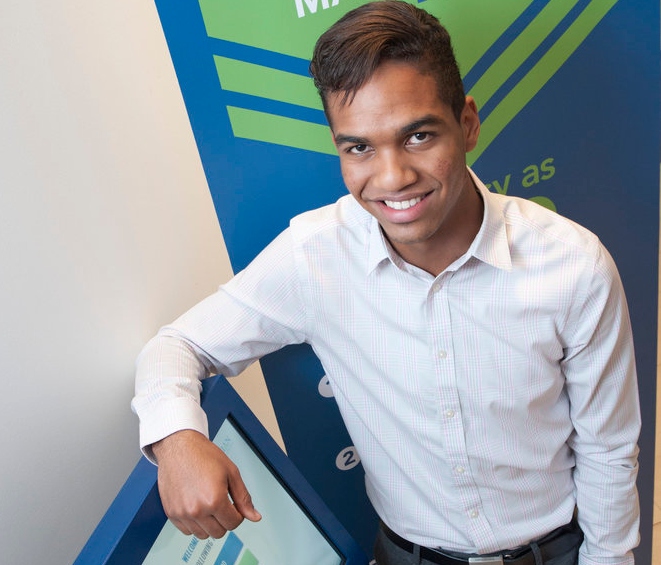 Male student standing beside registrar sign in station