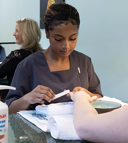 Wellness and Esthetics student works on hand and nail client