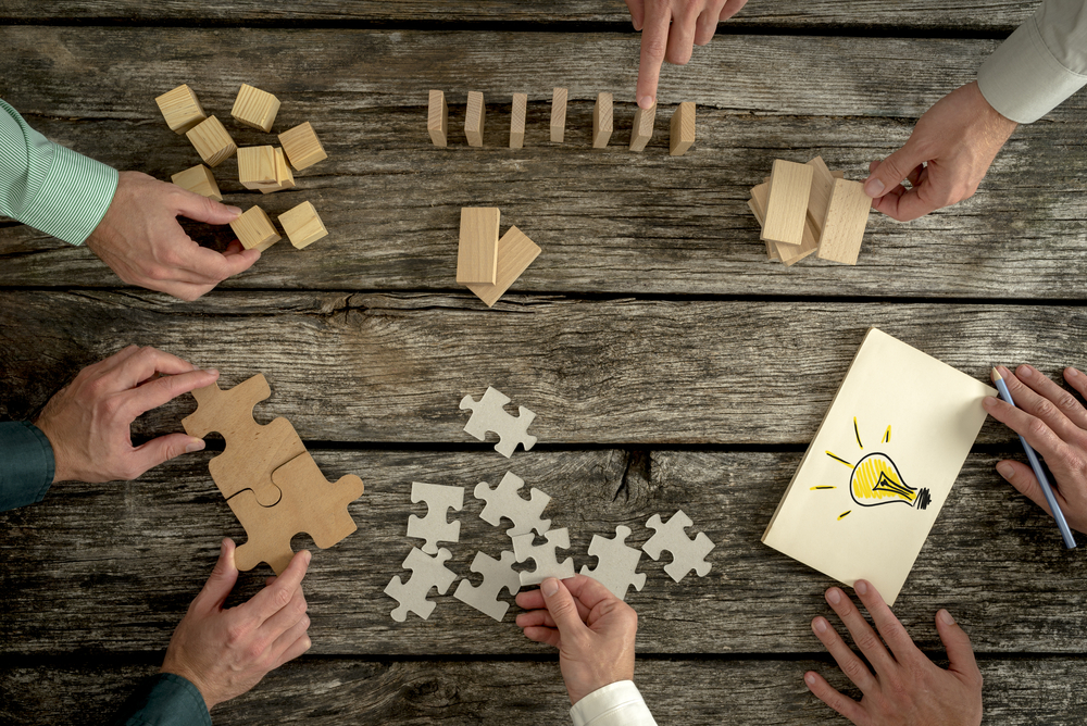 aerial view of hands handling blocks and puzzle pieces