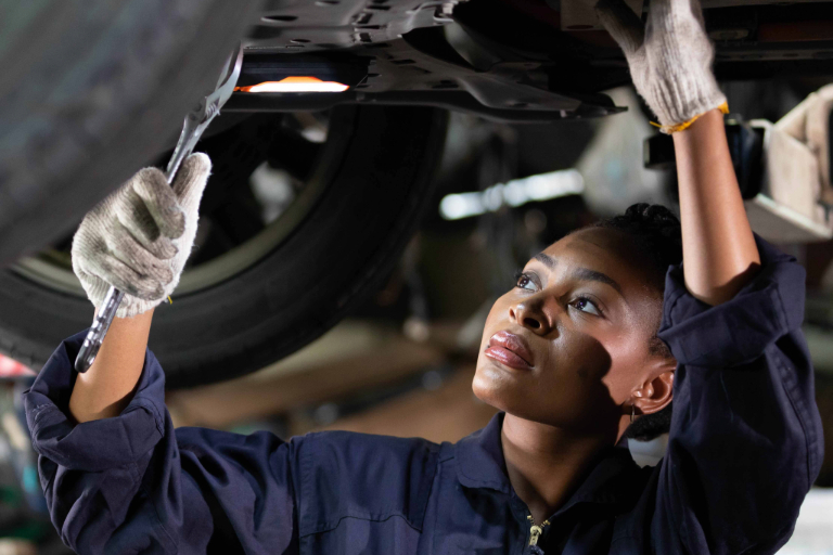 Person with wrench fixing car