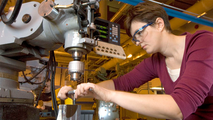 female student wearing safety goggles working with precision equipment at Georgian's Barrie Campus