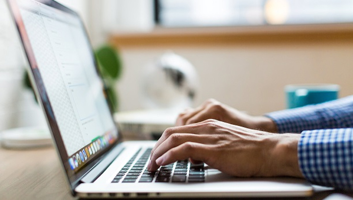 hands typing on a laptop computer