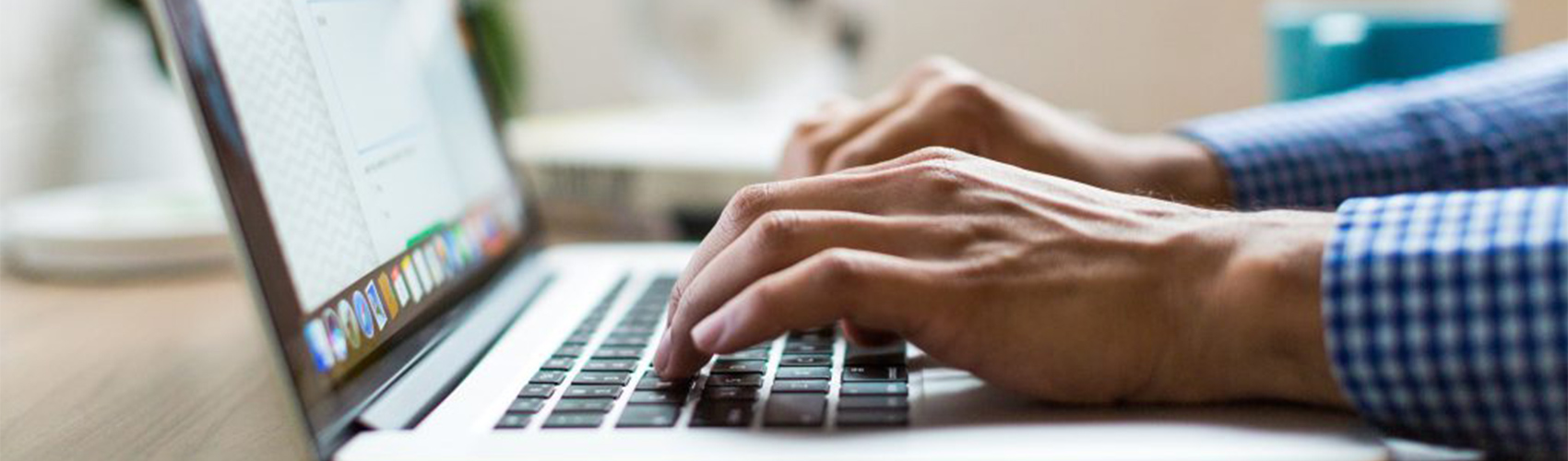 hands typing on a laptop computer
